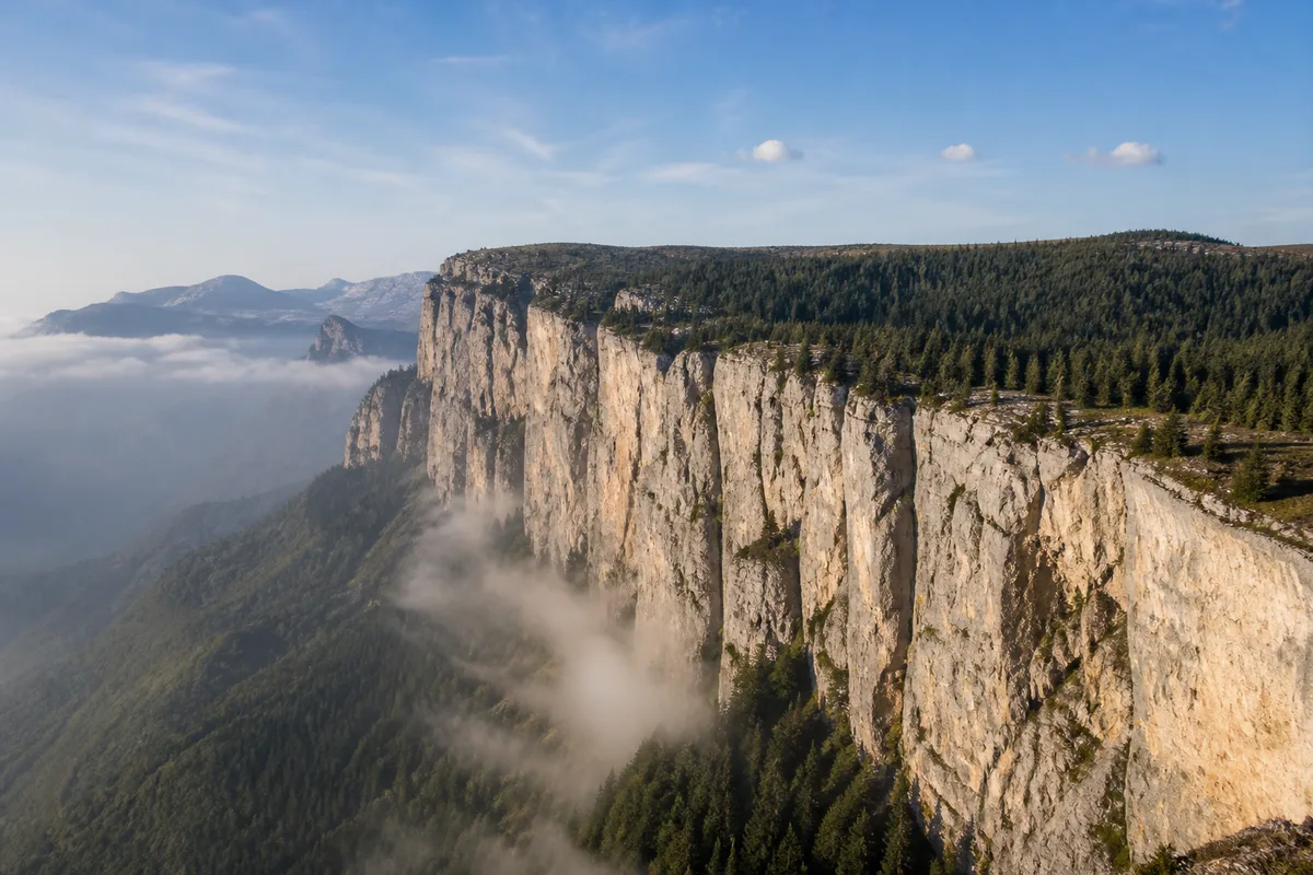 Falaises calcaires du Vercors au-dessus d&rsquo;une vallée noyée de brume
